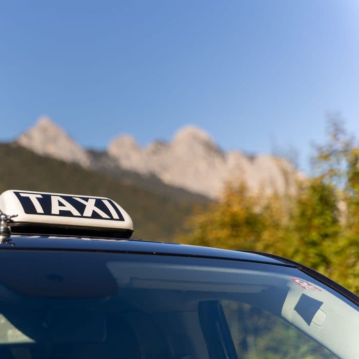 Taxischild auf dem Dach, im Hintergrund die Berge rund um Seefeld